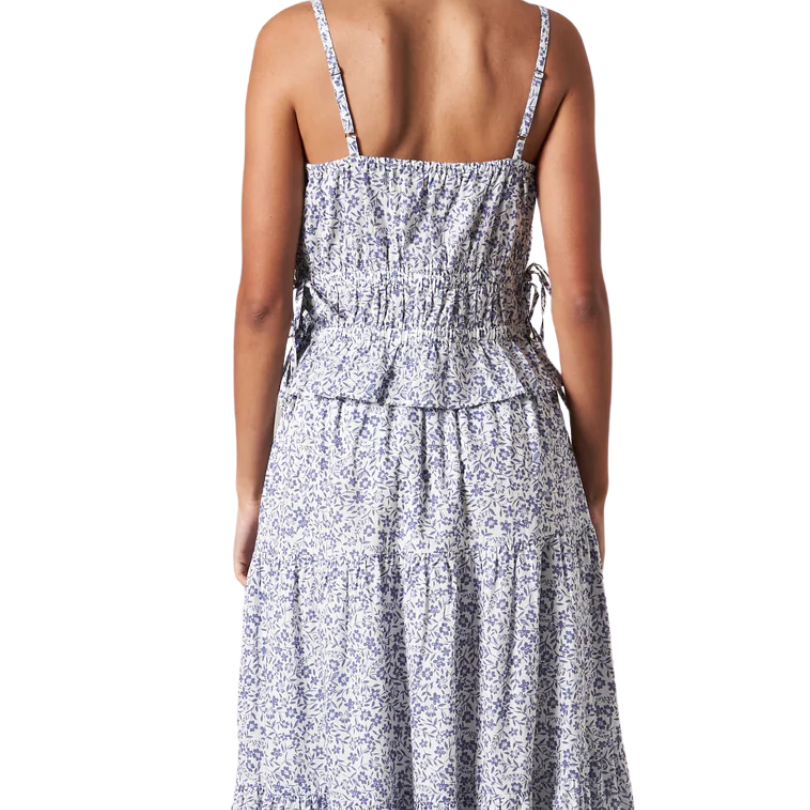 Woman wearing a floral dress with thin straps on a white background