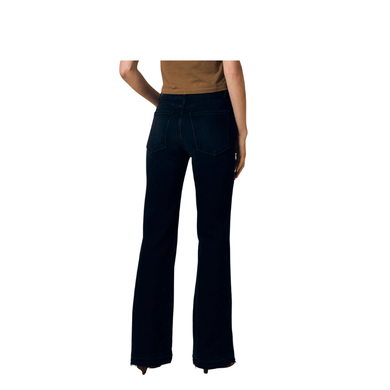 Person wearing black flared jeans on a white background