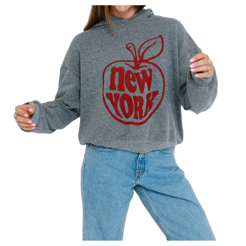 Person wearing a gray hoodie with a red 'New York' design on a white background
