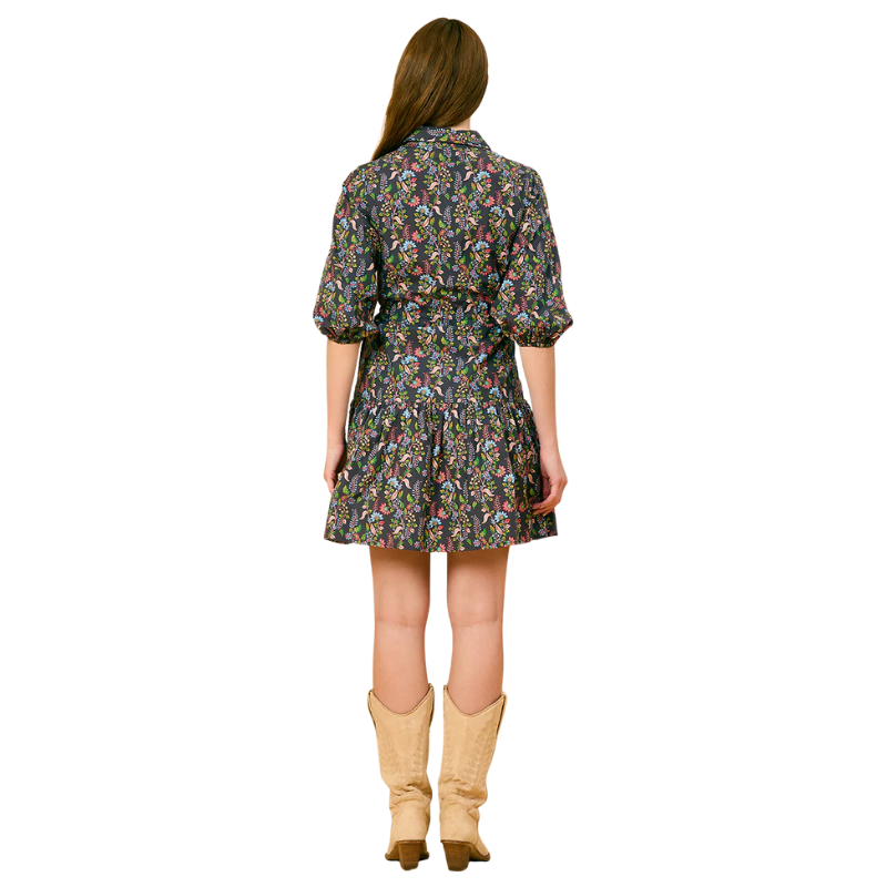 Woman wearing a floral dress and beige boots on a white background