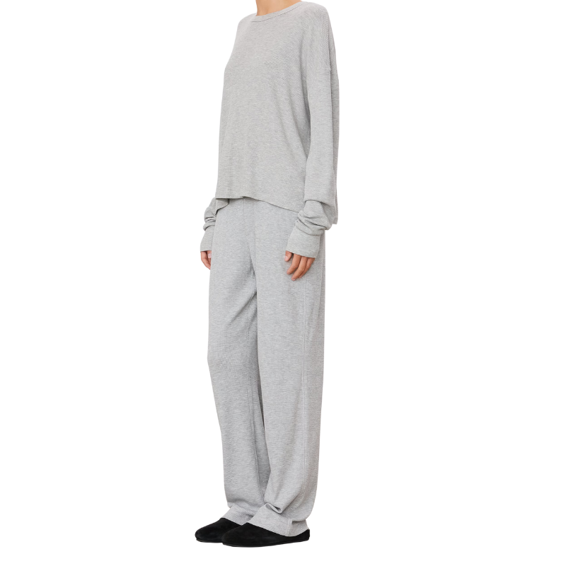 Person wearing a gray outfit on a white background