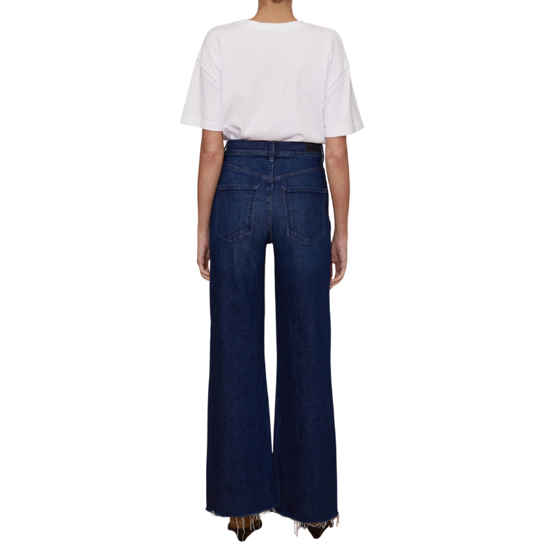 Person wearing a white t-shirt and dark blue wide-leg jeans on a white background