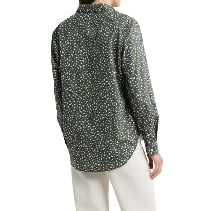 Person wearing a patterned shirt and white pants on a white background