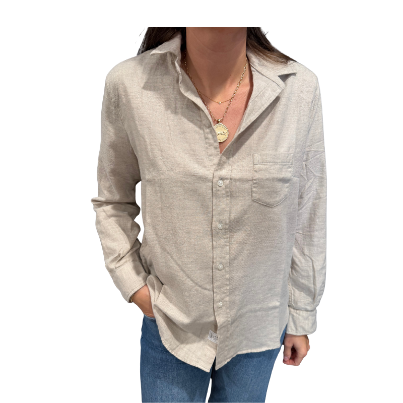 Beige button-up shirt worn by a person on a white background