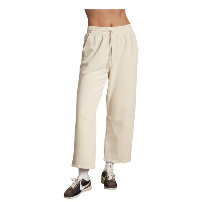 Beige pants worn by a person on a white background