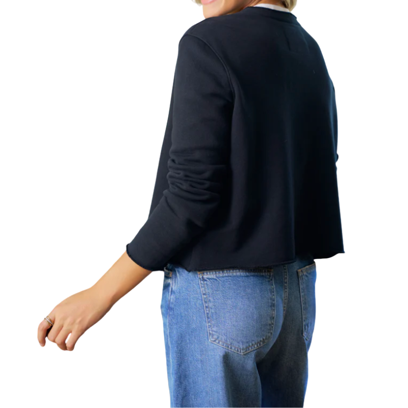 Person wearing a navy sweater and blue jeans on a white background