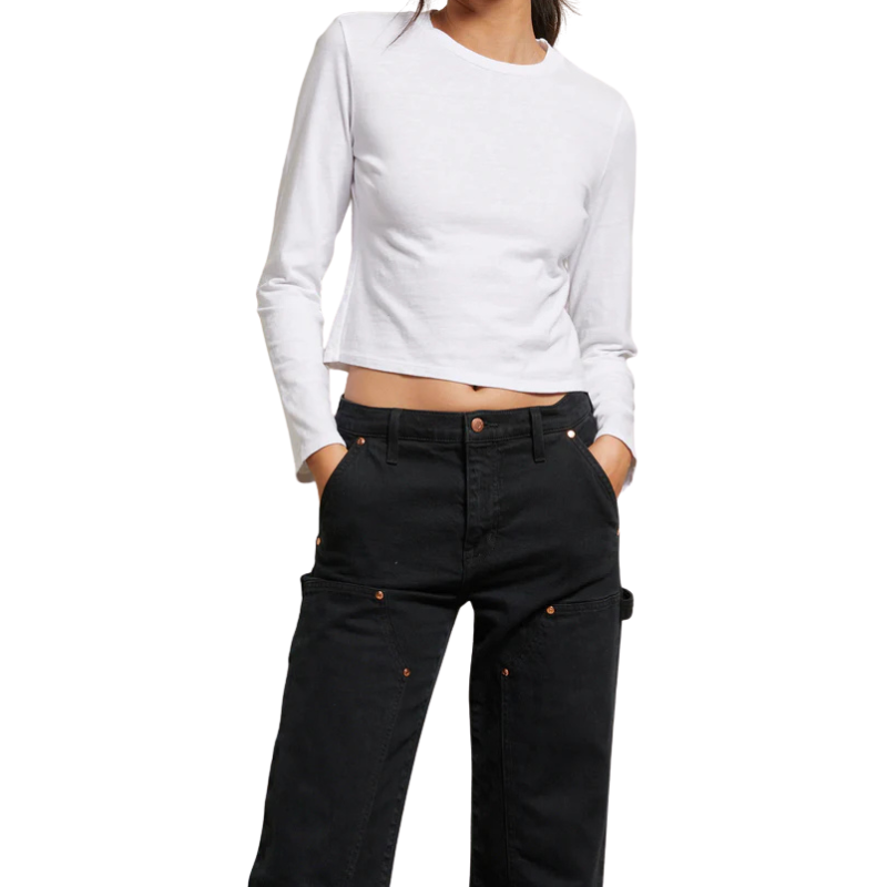 Person wearing a white long-sleeve crop top and black pants on a white background