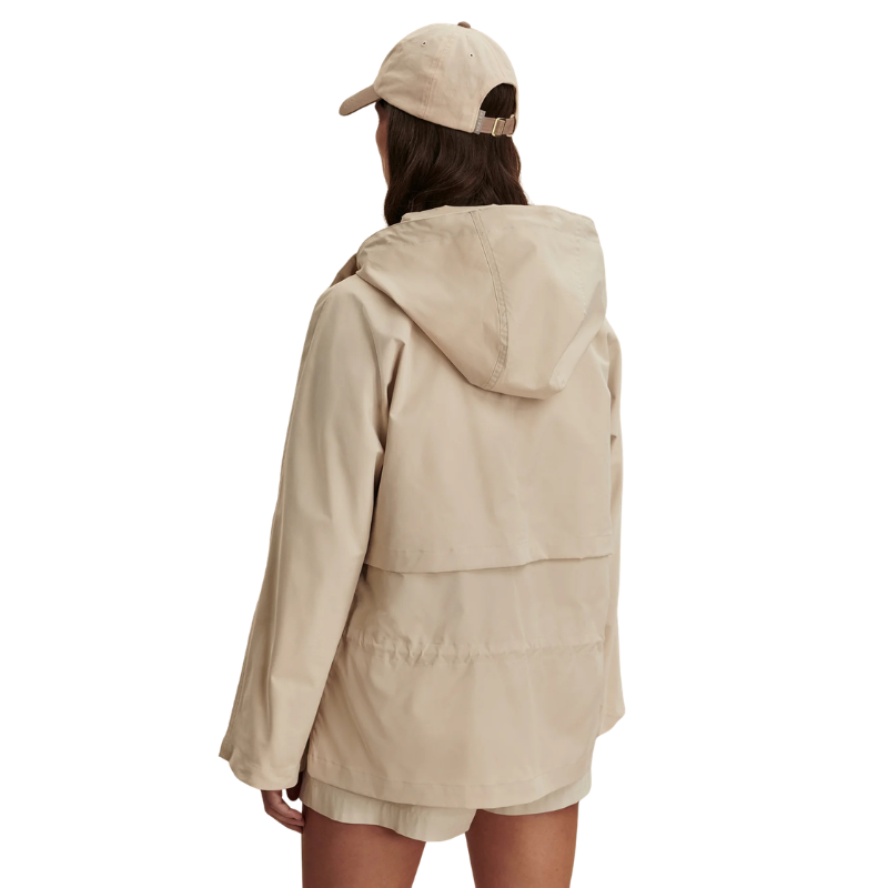 Person wearing a beige jacket and cap on a white background