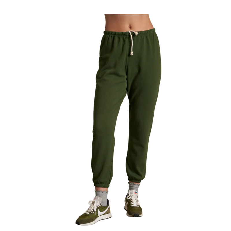 Green sweatpants worn by a person on a white background