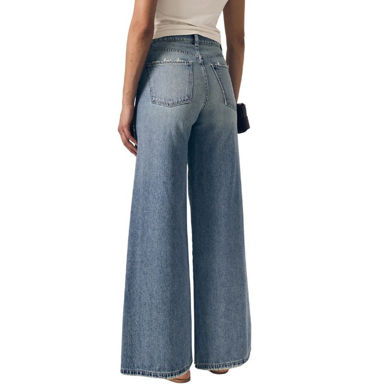 Person wearing light blue wide-leg jeans on a white background