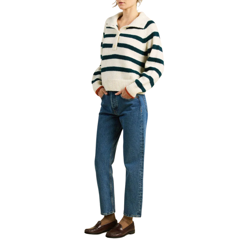 Person wearing a striped sweater and blue jeans on a white background