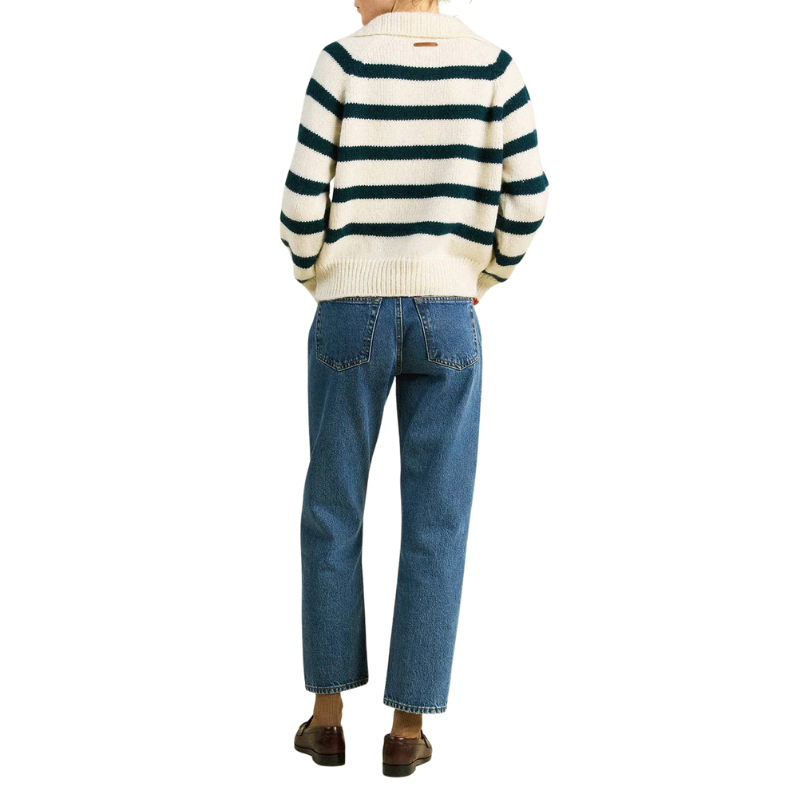 Person wearing a striped sweater and blue jeans on a white background