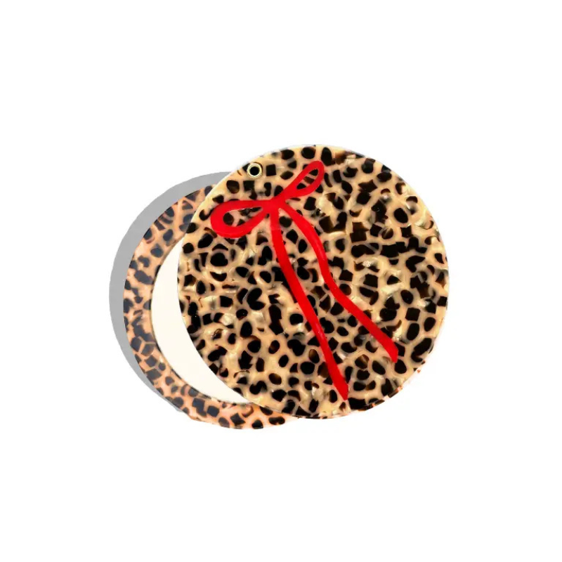 Leopard print product with a red ribbon on a white background
