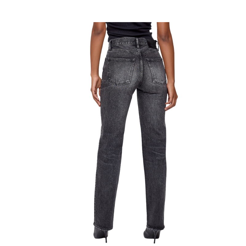 Person wearing black acid-wash jeans on a white background