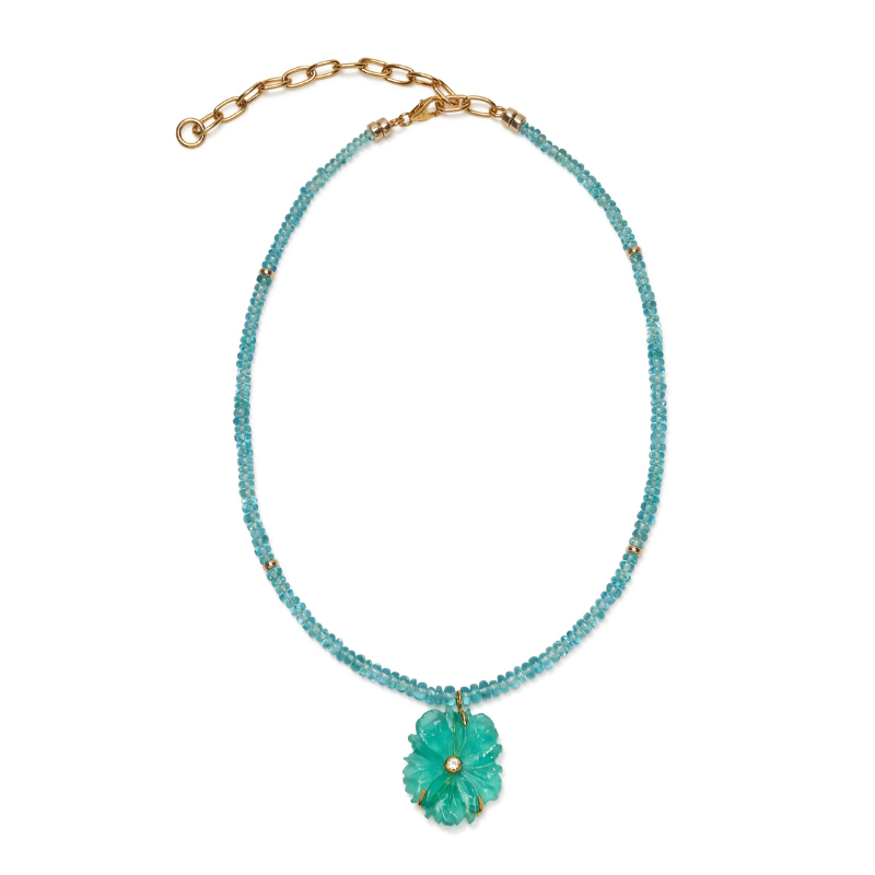 Turquoise beaded necklace with a green floral pendant on a white background
