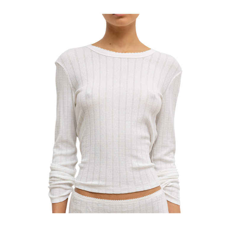 White ribbed long-sleeve top worn by a person on a white background