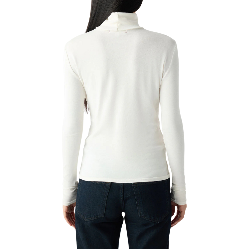 Person wearing a white long-sleeve top and dark pants on a white background