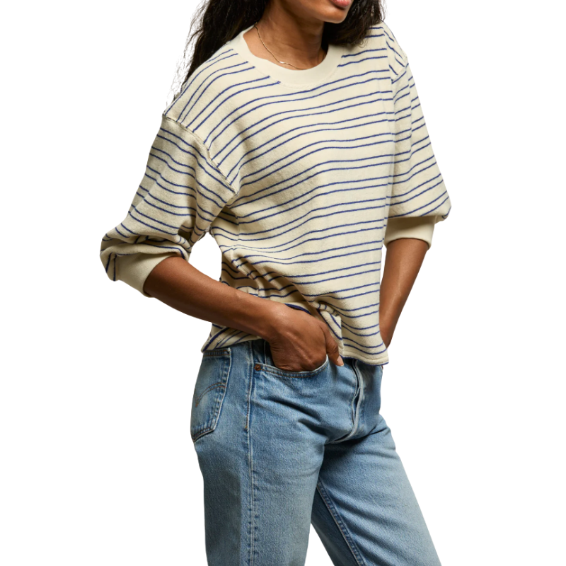 Person wearing a striped sweater and jeans on a white background