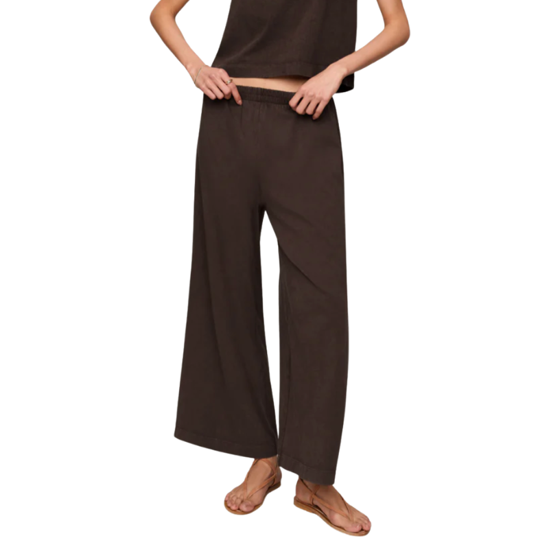 A model wearing dark brown wide-leg pants and a matching dark brown top, shown from the waist down against a plain white background.