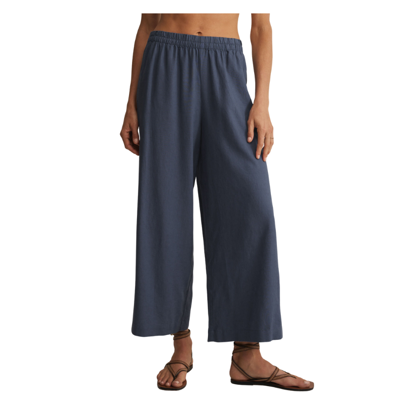 Person wearing blue wide-leg pants on a white background