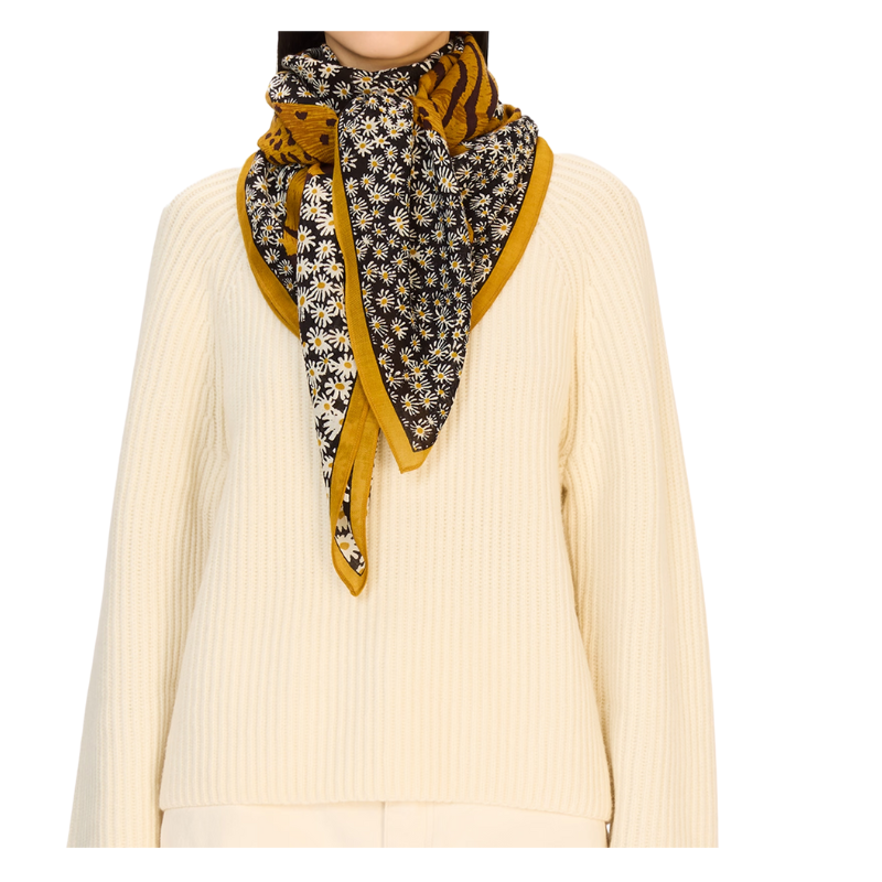 Person wearing a patterned scarf with yellow and black design on a white background
