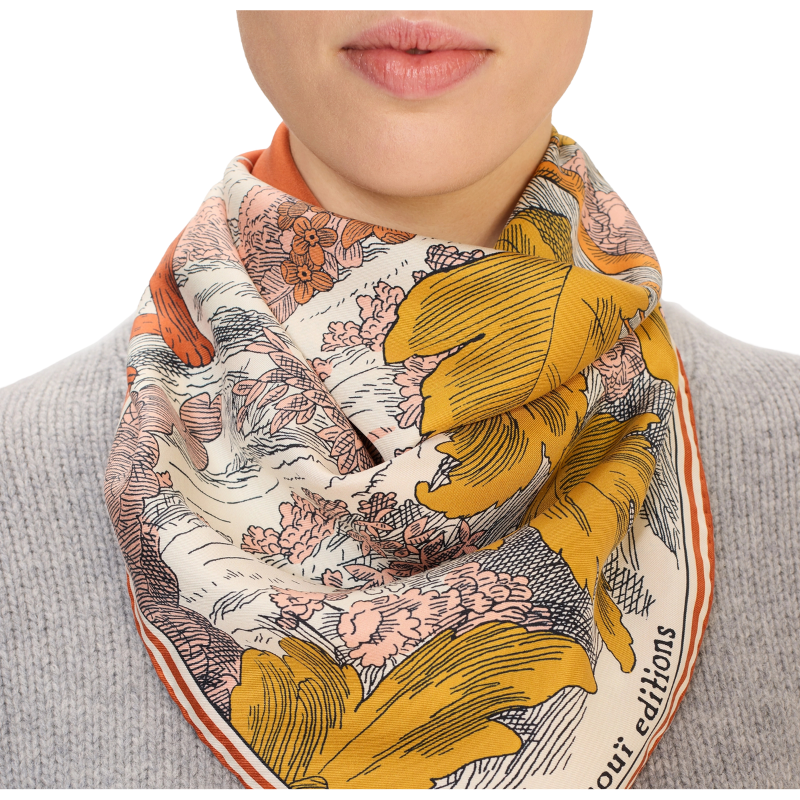 Person wearing a colorful floral scarf with a neutral background