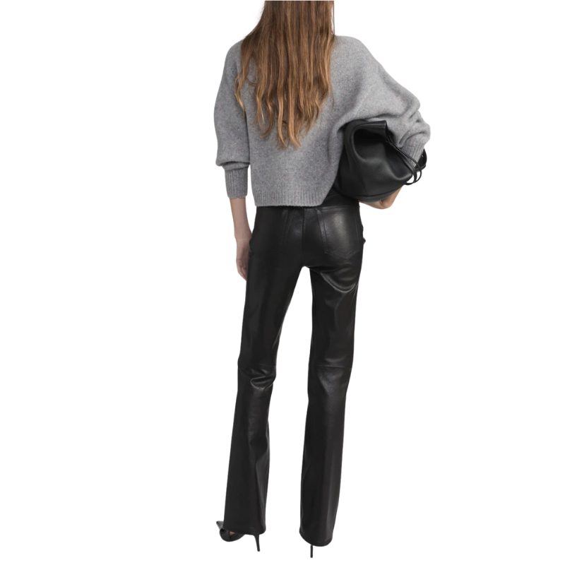 Person wearing black leather pants and a gray sweater on a white background