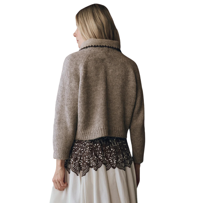 Woman wearing a brown sweater with lace trim on a white background