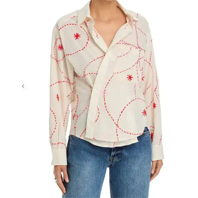 White blouse with red patterns worn by a person on a white background