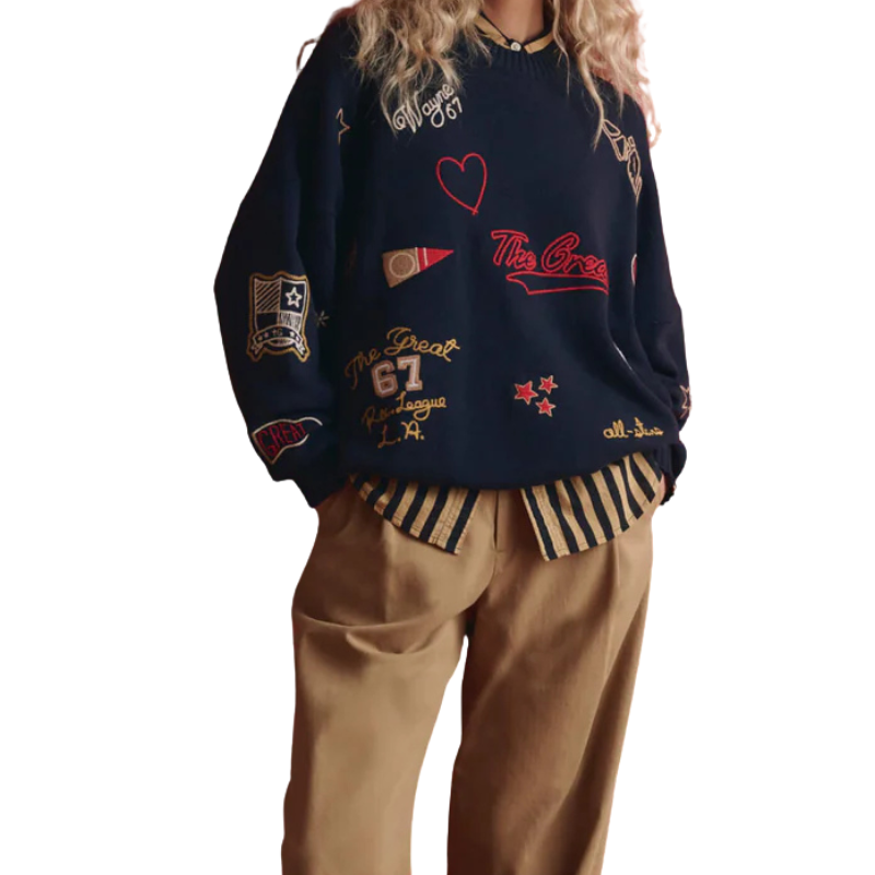 Person wearing a navy sweater with various text and logo designs on a white background