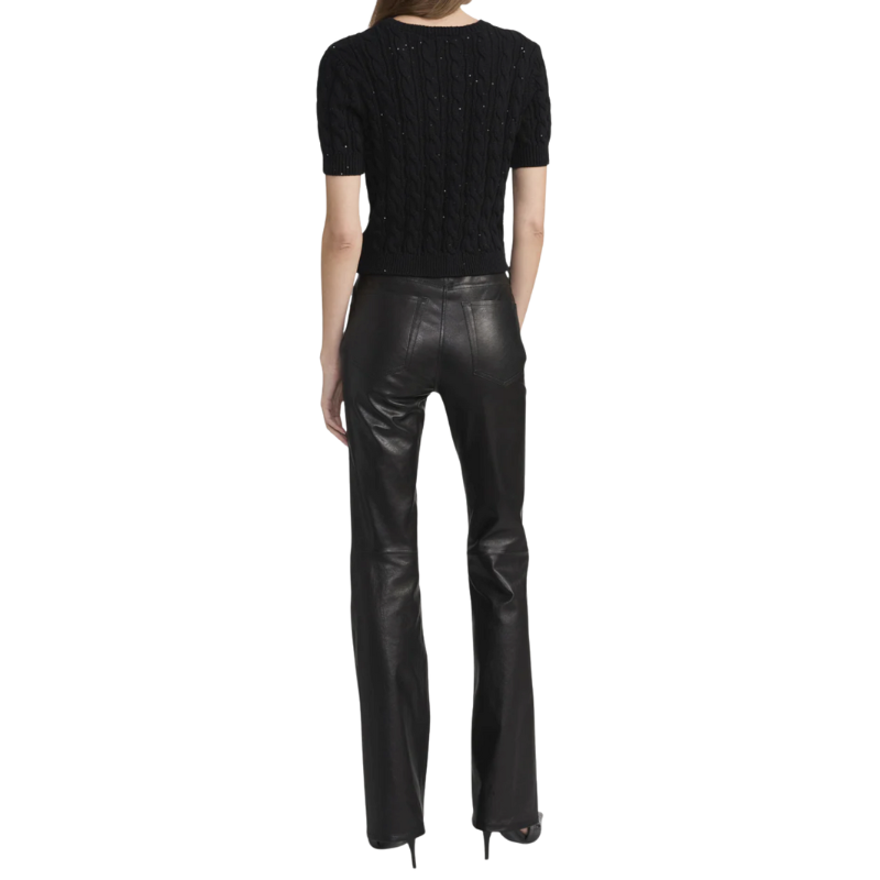 Person wearing a black short-sleeve top and black leather pants on a white background