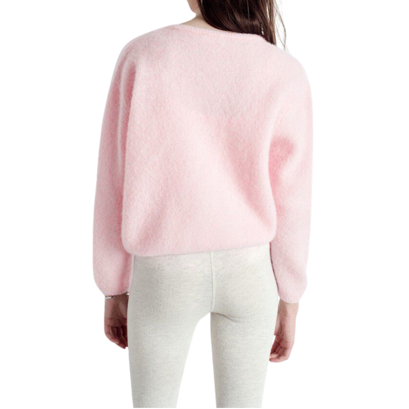 Pink sweater worn by a person on a white background