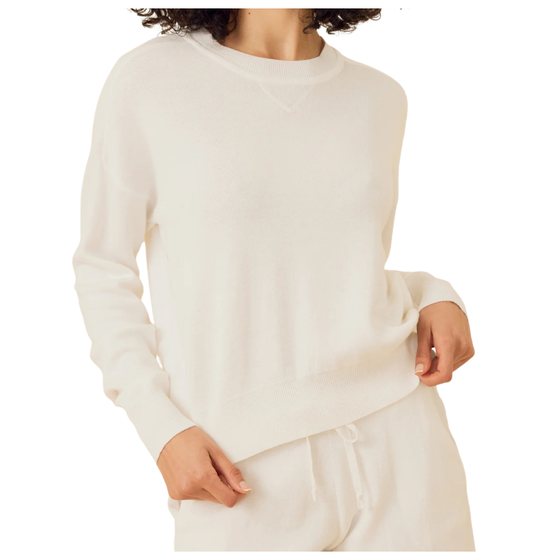 Person wearing a white sweater and pants on a white background
