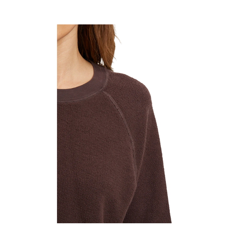 Brown sweater worn by a person on a white background