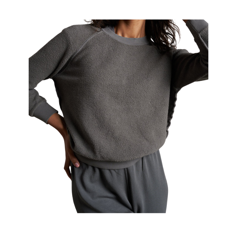 Person wearing a gray sweater and pants on a white background