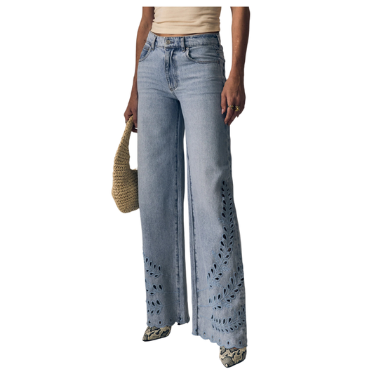 Person wearing light blue jeans with cut-out details on a white background