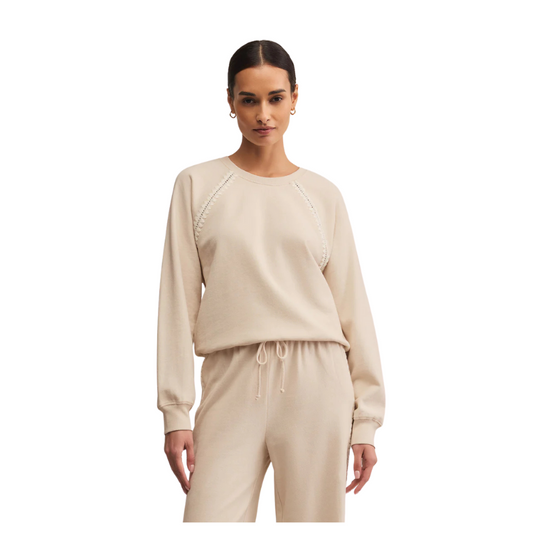 Woman wearing a beige sweatshirt and pants on a white background