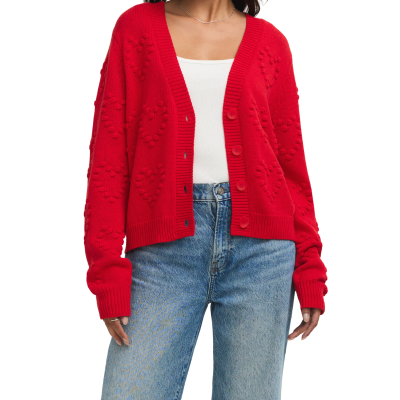 Red cardigan worn over a white top and blue jeans on a white background