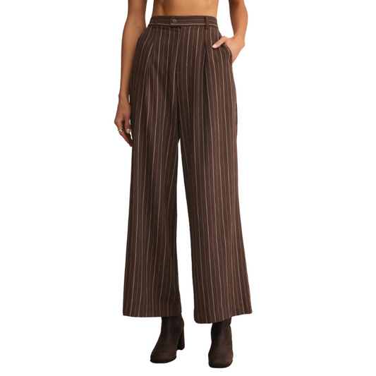 Brown pinstripe pants worn by a person on a white background