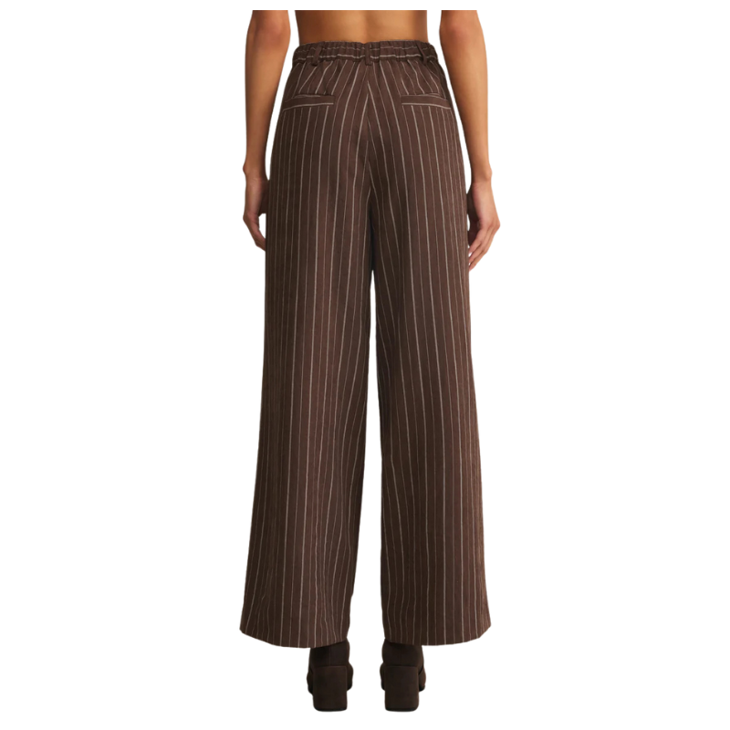 Brown pinstripe pants worn by a person on a white background