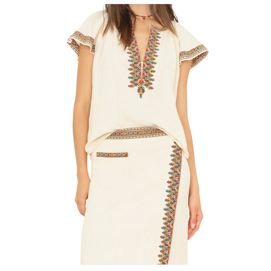 Beige dress with colorful embroidery on a white background
