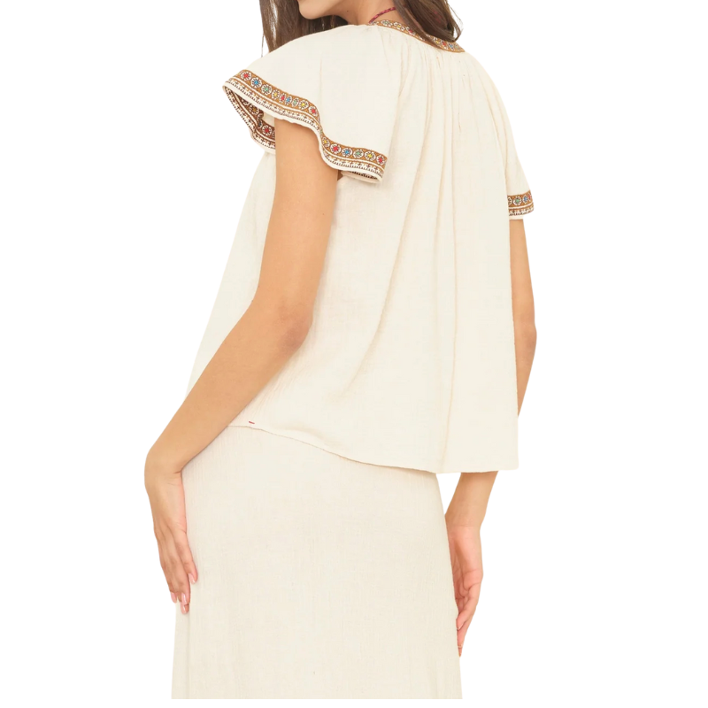 White dress with embroidered sleeves on a white background