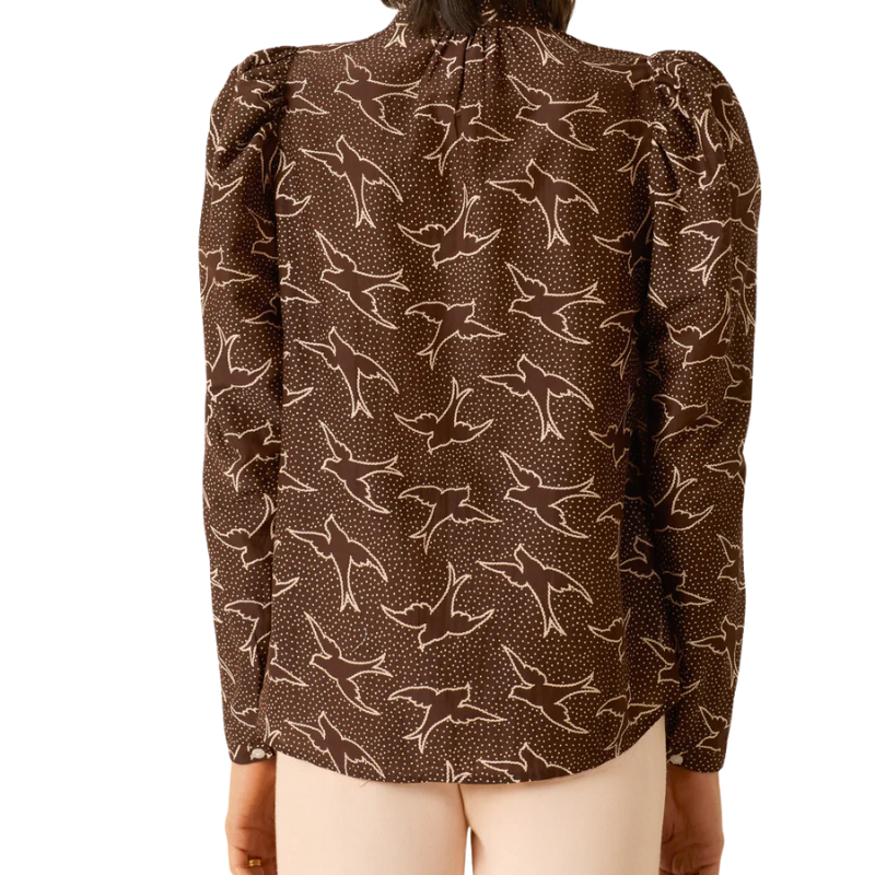 Brown blouse with bird pattern on a mannequin against a white background