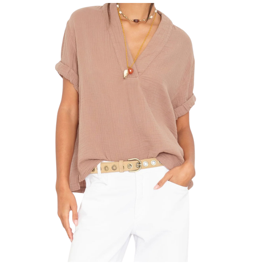 Person wearing a brown blouse and white pants on a white background