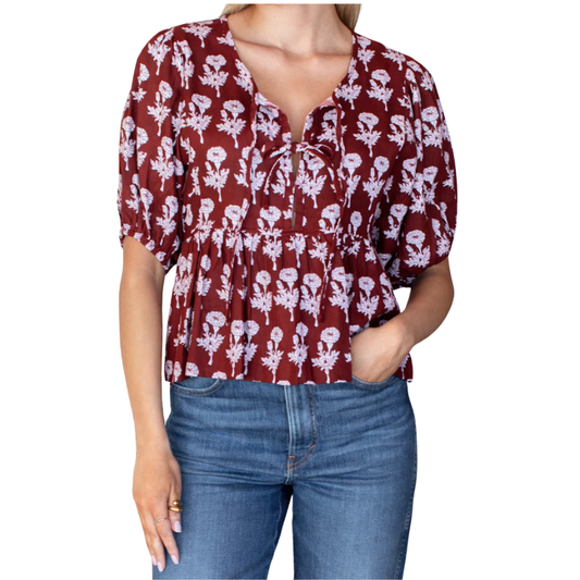 Red floral blouse worn by a person on a white background