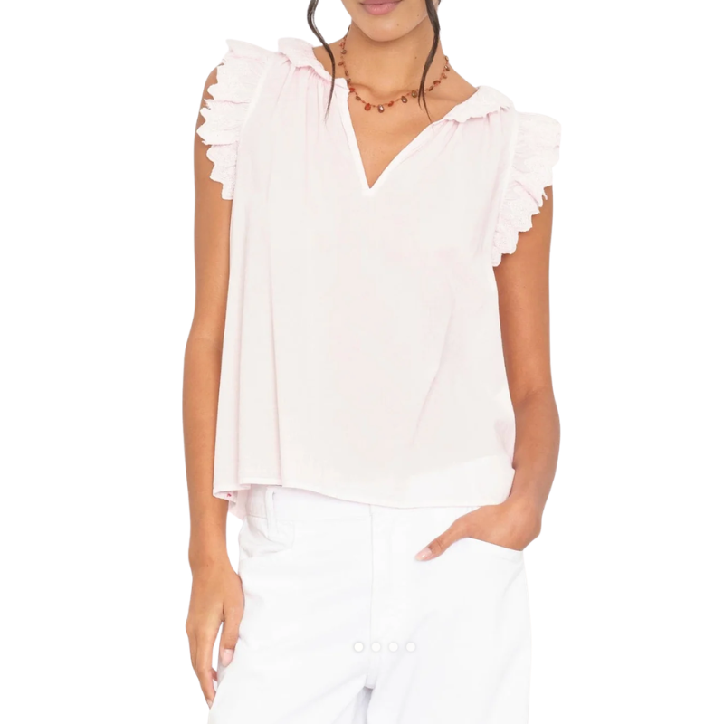 Woman wearing a white sleeveless top with ruffled shoulders on a white background