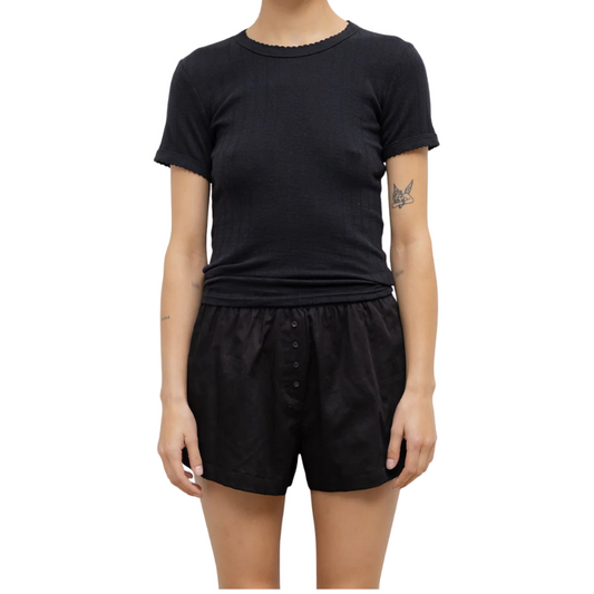 Person wearing a black t-shirt and black shorts on a white background