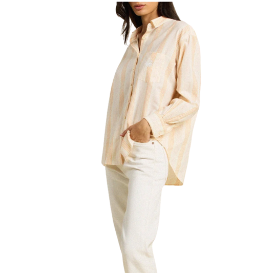 Woman wearing a beige striped shirt and white pants on a white background