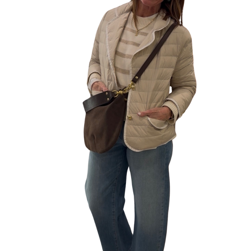 Woman holding a brown leather bag against a white background