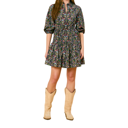 Woman wearing a floral dress and beige cowboy boots on a white background